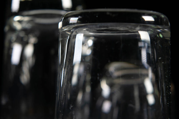 Three empty shot glasses on black background. - Foto, Imagem