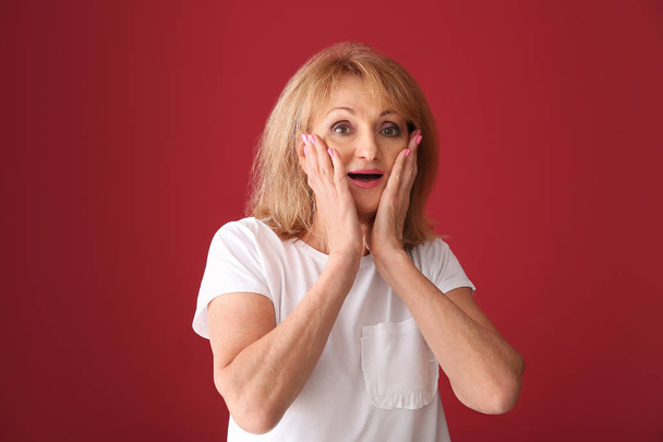 Portrait of excited mature woman on color background - Foto, immagini