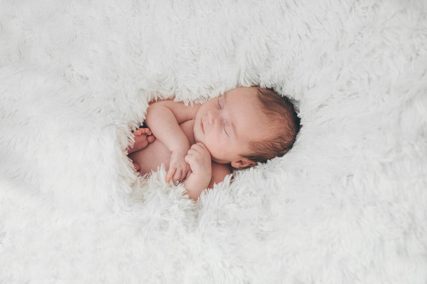 naked newborn baby sleeping curled up in a ball - Fotografie, Obrázek