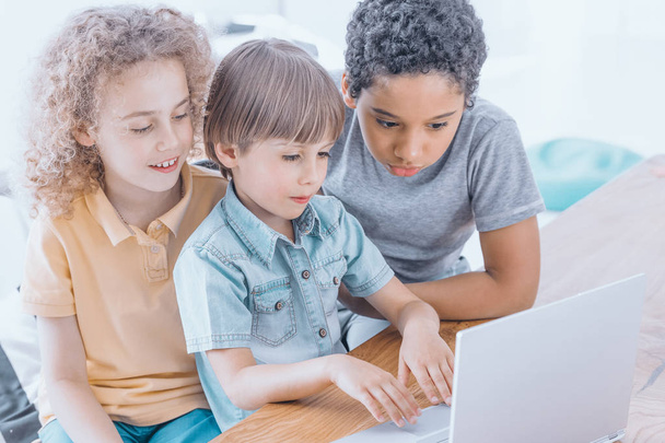 Group of clever kids learning together how to use computer - Photo, image