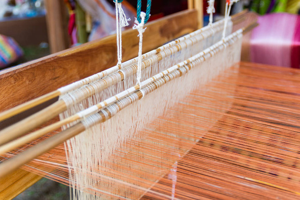 Webereiausrüstung Haushaltsweberei - Detail des Webstuhls für hausgemachte Seide, die für die Seidenweberei oder Textilherstellung in Thailand verwendet wird  - Foto, Bild