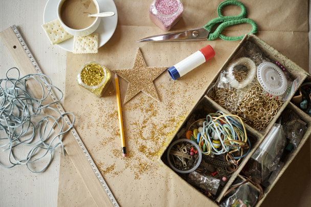 Close-up van werktafel met decor elementen en verschillende objecten voor het naaien handgemaakte werk voorbereiden - Foto, afbeelding