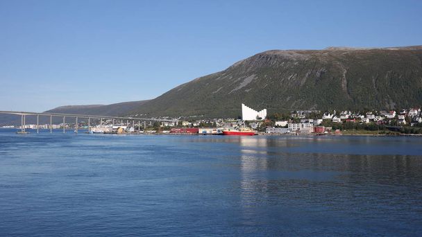 Tromso city and Ishavskatedralen panorama reflected in a fjord, north of Norway - Photo, image