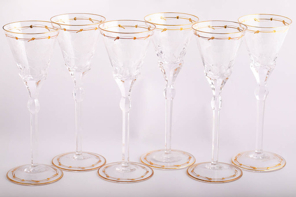 Stemware faceted glasses made of Czech glass with a Golden lines and ornament isolated on a white background. - Fotografie, Obrázek