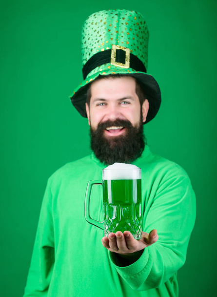 Fresh and green. Irish man with beard drinking green beer. Bearded man toasting to saint patricks day. Celebrating saint patricks day in bar. Hipster in leprechaun hat holding beer mug - Fotografie, Obrázek