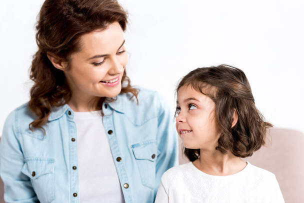 усміхнена мати і дочка дивляться один на одного ізольовані на білому
  - Фото, зображення