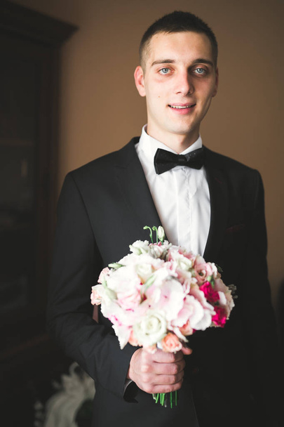 Happy handsome smiling groom posing with boutonniere - Photo, Image