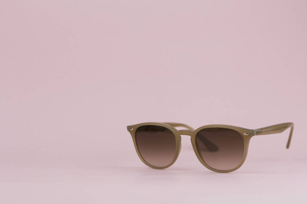 Brown sunglasses on a pink background. Background - 写真・画像