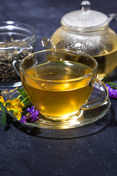čaj s aromatickými bylinkami na tmavý stůl, vertikální - Fotografie, Obrázek