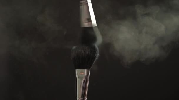 Two makeup brushes with powder on a dark background, slow motion - Filmagem, Vídeo