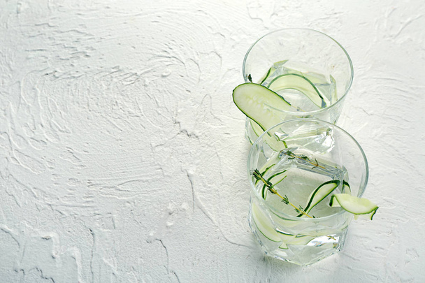 Glasses of fresh cucumber water on white table - Fotó, kép