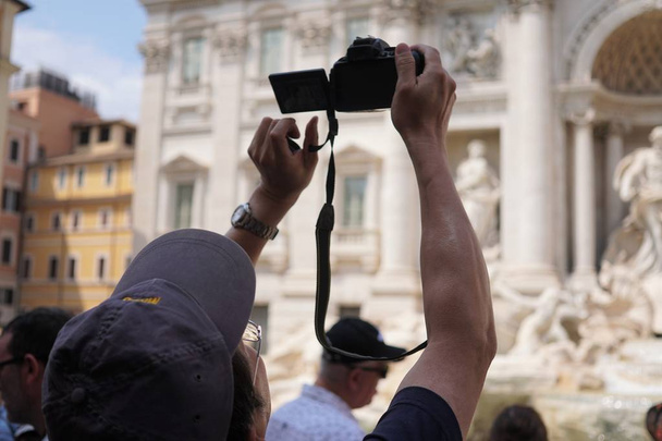 Rome, Italie - 10 août 2018 : Touriste prenant une photo de la célèbre fontaine de Trevi. Concentration sélective
 - Photo, image