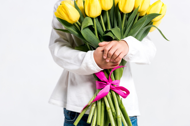 Cropped view of child holding bouquet of yellow tulips isolated on white - Foto, Bild