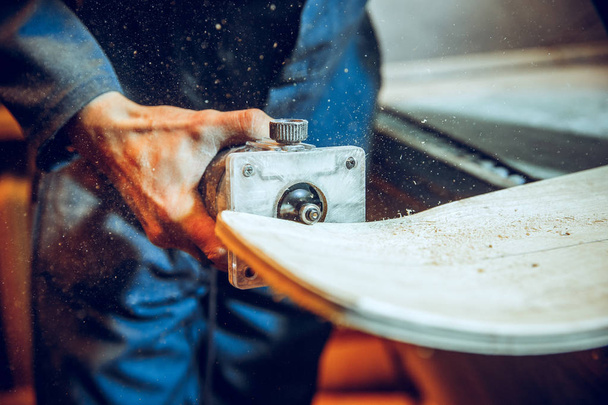 Carpenter using circular saw for cutting wooden boards. - 写真・画像