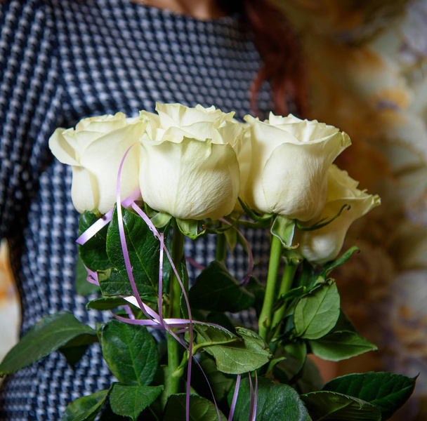 Um buquê de flores nas mãos da menina. Um buquê de rosas brancas
. - Foto, Imagem