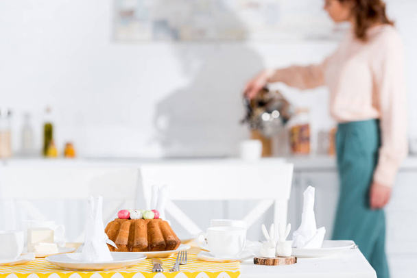 Serviertisch mit Osterkuchen, Geschirr und Servietten in der Küche - Foto, Bild