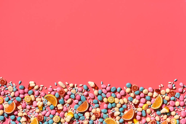 Various sweets, candys are palced on the photo on the coral background - Fotoğraf, Görsel