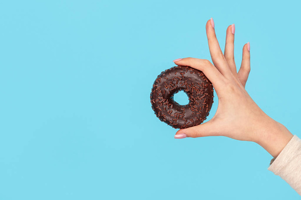 Chocolate glazed doughnut in female hand  - Foto, Bild