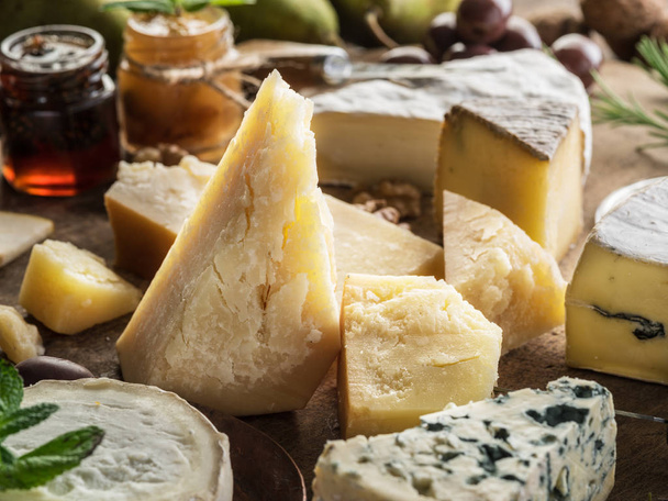 Piece of Parmesan cheese and assortment of different cheeses at  - Foto, imagen
