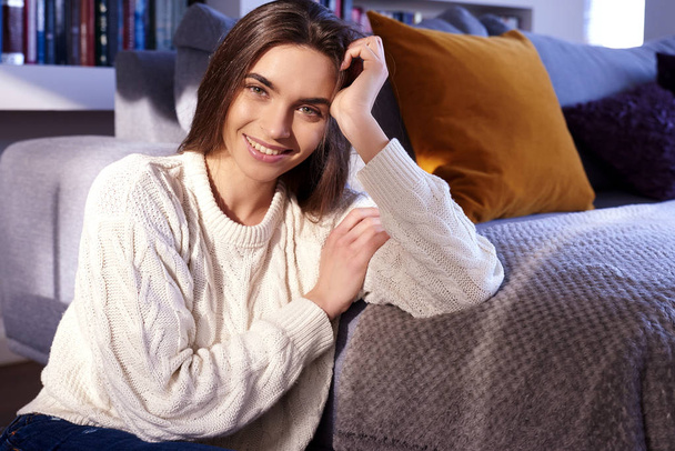 Portrait shot of beautiful young woman relaxing at home while looking at camera and smiling.  - Φωτογραφία, εικόνα