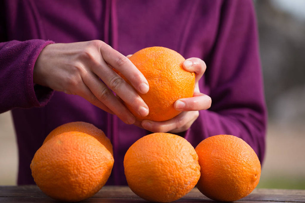 Woman peels oranges from peel.  - Photo, Image
