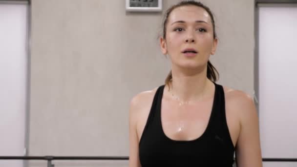close view pretty young brunette woman in black top balances with pink dumbbells in sports club - Footage, Video