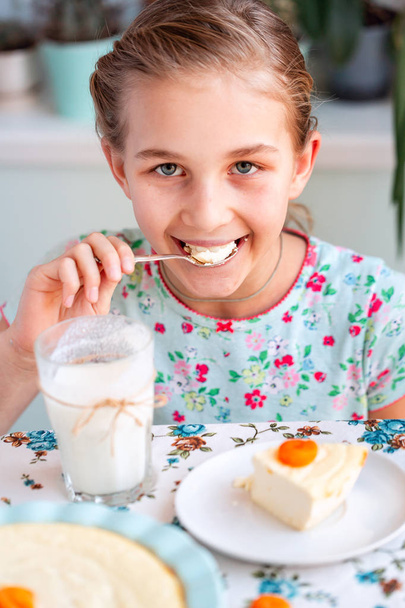 Beautiful little girl eating breakfast in kitchen at home - Фото, зображення