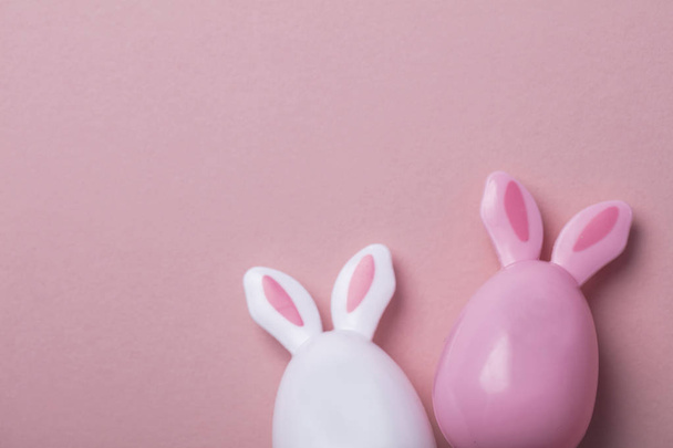 Easter eggs with bunny ears on a pastel pink background - 写真・画像