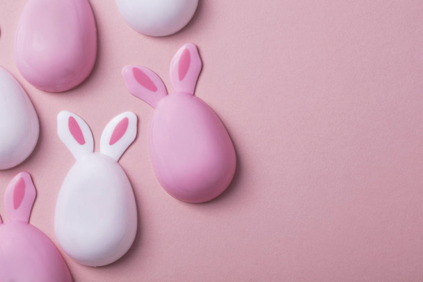 Easter eggs with bunny ears on a pastel pink background - Valokuva, kuva
