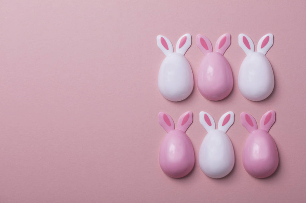 Easter eggs with bunny ears on a pastel pink background - Zdjęcie, obraz