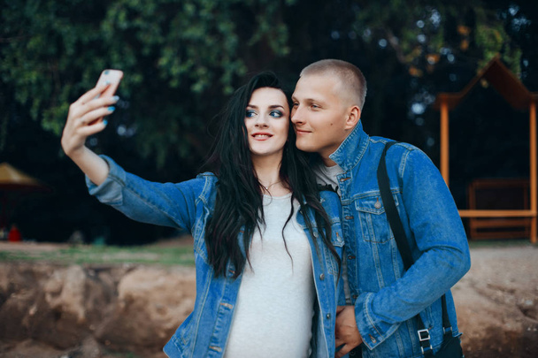 Ihana pari kävelee puistossa ja ottaa selfie yhdessä
 - Valokuva, kuva