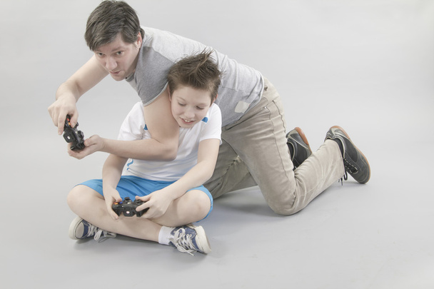 Хлопчик і чоловік грають у відеоіграх
 - Фото, зображення