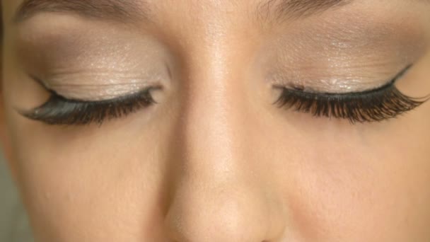 Closeup girlss face with closed eyes and long false lashes. Beautiful female model with gorgeous makeup - Metraje, vídeo