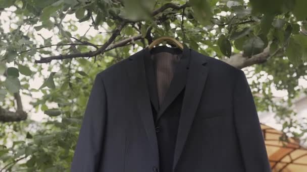 The brides jacket is hanging in a garden on a tree. - Footage, Video