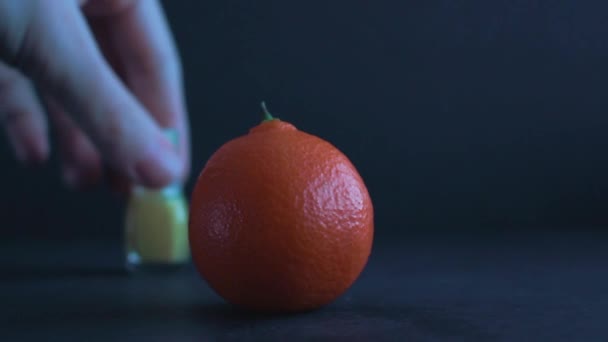 Close Up Of A Porous And Bright Orange Mandarin On A Dark Blue Surface  - Кадры, видео