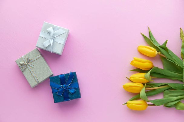 Tulipanes amarillos y cajas de regalo sobre fondo rosa con espacio para copiar
 - Foto, Imagen
