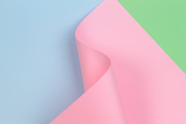 Abstract geometric pink paper shape on blue and green color paper background - Photo, Image