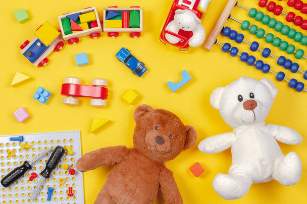 Детские игрушки на желтом фоне. Вид сверху
 - Фото, изображение