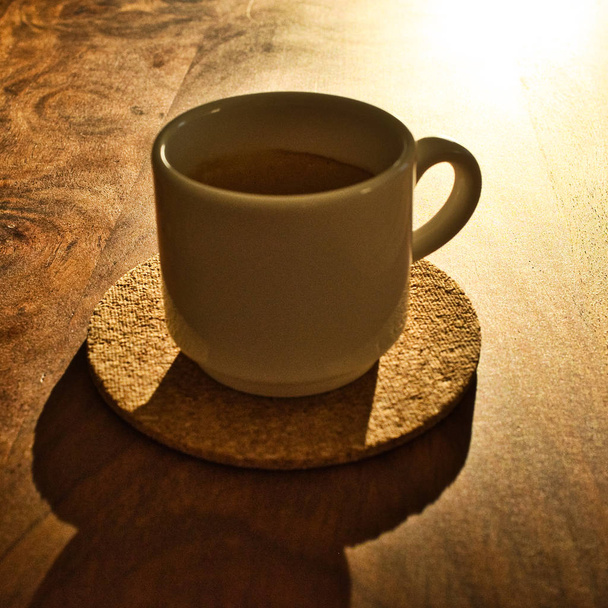 低い日差しの中で木製のプレート上のエスプレッソのカップ。テキストの場所 - 写真・画像