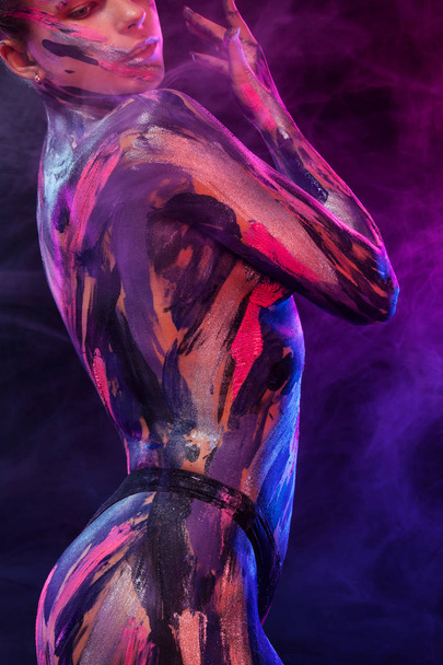 Young woman painted different colors. Inspired dance to music. Body art colorful. An amazing woman with art fashion makeup and bodyart. - Foto, Imagem