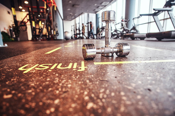 Manubri sdraiati sul pavimento nel centro fitness
.  - Foto, immagini
