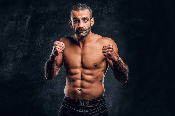 Portrait of a brutal professional fighter with naked torso posing for a camera. - Photo, Image