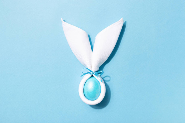 Easter bunny ears with egg on blue background. - Photo, Image