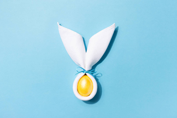 Osterhasenohren mit Ei auf blauem Hintergrund. - Foto, Bild