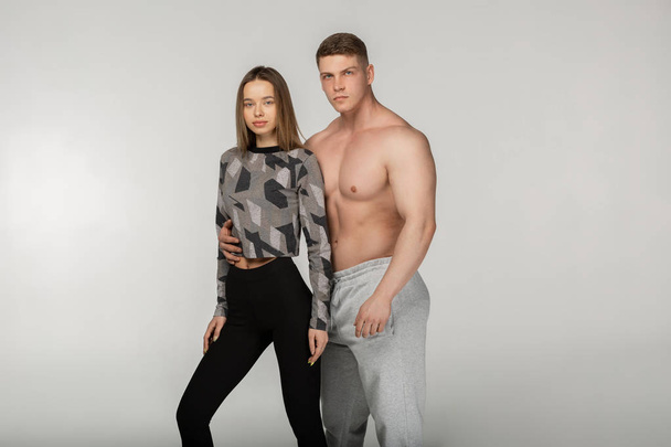 Athletic shirtless man and sporty woman in stylish sportswear - Фото, зображення