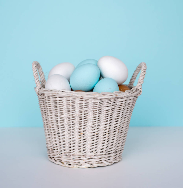 Концепция праздника весны и Пасхи. Пасхальные яйца окрашены в синий и белый, пастельный цвет фона. Изолированные на белом
. - Фото, изображение