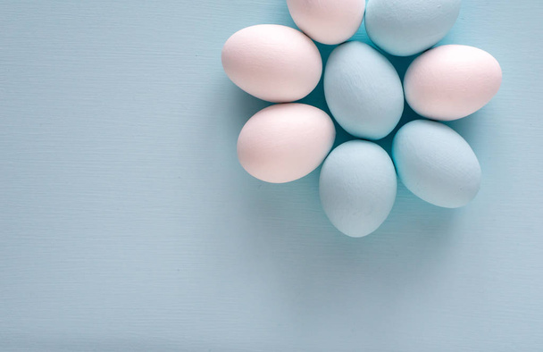 Concepto de vacaciones de primavera y Pascua. Huevos de Pascua pintados de azul y blanco, fondo de color pastel. Aislado sobre blanco
. - Foto, Imagen