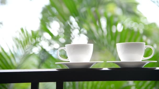 close-up footage of cups of coffee standing on balcony in front of nature background - Footage, Video