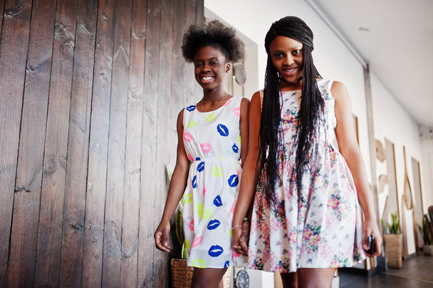 Two black african girlfriends at summer dresses walking in moder - Foto, imagen