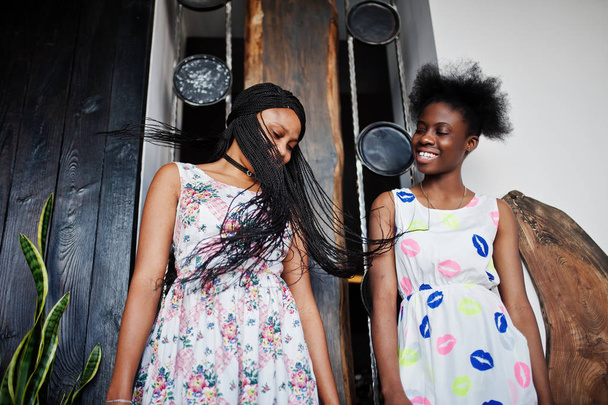 Two black african girlfriends at summer dresses posed indoor and - Photo, image